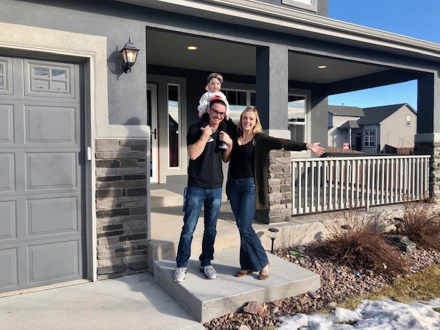 Homeowners in front of their newly purchased home in colorado springs
